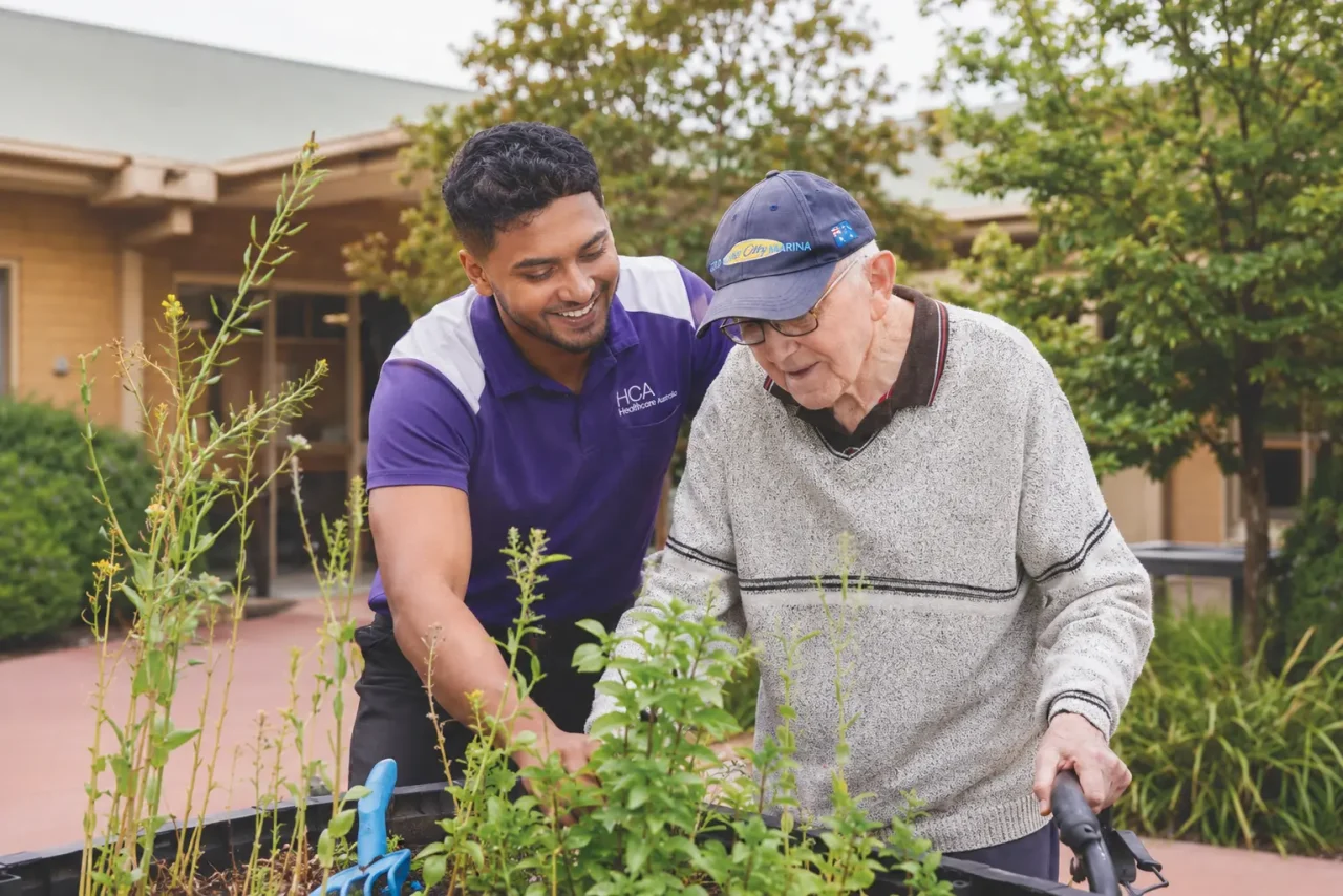 Elderly man outsit with support worker in garden
